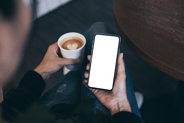 cell phone mockup image blank white screen.woman hand holding texting using mobile on desk at coffee shop.background empty space for advertise.work people contact marketing business,technology
