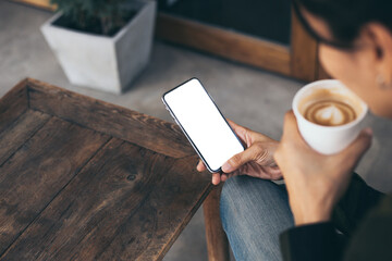 cell phone mockup image blank white screen.woman hand holding texting using mobile on desk at coffee shop.background empty space for advertise.work people contact marketing business,technology