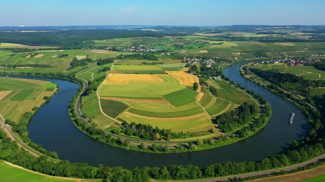 River curving in u shape around farm and woodland, road alongside riverbank.