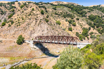 Bridge going over Coyote Creek in South San Francisco Bay Area, California; low water level visible...