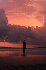 Fototapeta na wymiar social distancing on the beach , pink and orange amazing cloudy sky , beautiful sunset , Bali Indonesia , solo outdoor walking 