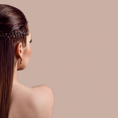 Young sensual woman with braids, back half-side view