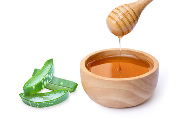 Closeup green fresh aloe vera leaf with pure honey in wooden bowl isolated on white background. Natural herbal medical plant, skin care, health and beauty spa concept.