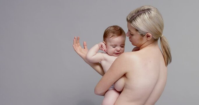 SLO MO MS Shirtless mother holding baby son (6-11 months)