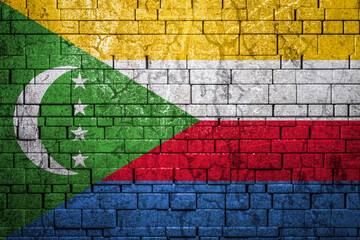 National flag of Comoros on brick  wall background.The concept of national pride and symbol of the...