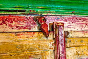 Old rusty gate latch on the door.