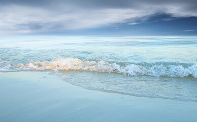 Fototapeta na wymiar Soft wave of the sea on the sandy beach.Summer vacation background.