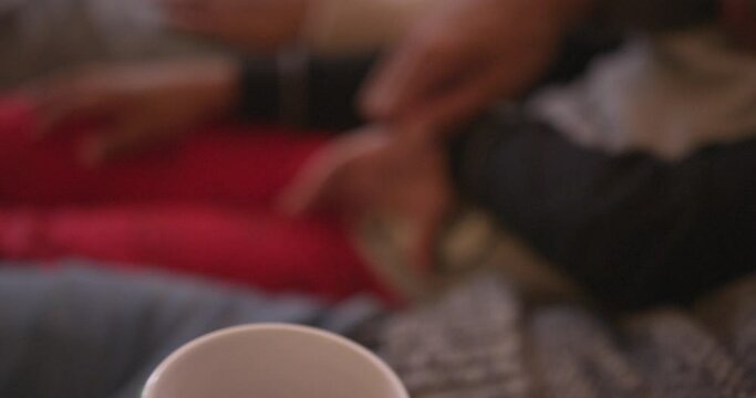 CU HANDHELD Man drinking tea from knitted mug / Dinton, Wiltshire, UK