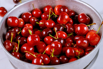 Prewashed ripe cherries with stem in colander.
