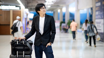 Business travel and baggage claim check-in concept. Smart Asian businessman wearing formal suit...