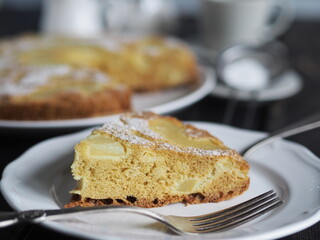 Sponge cake with pineapple on a dark wooden table.Home cooking.