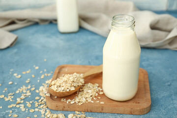 Bottle of tasty oat milk on color background