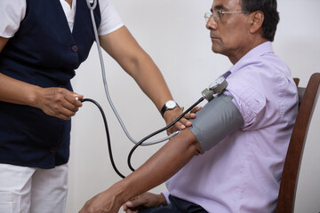 nurse taking blood pressure to a patient at home