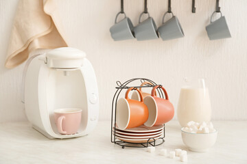 Holder with cups and saucers on kitchen table