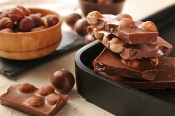 Tasty chocolate with nuts on table