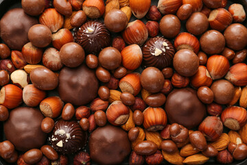 Tasty chocolate candies with nuts, top view