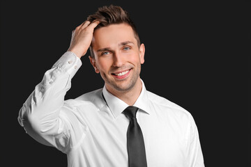 Portrait of handsome businessman on dark background