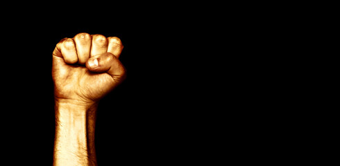 Male black fist on a black background. Aggressiveness, masculinity, the concept of challenge