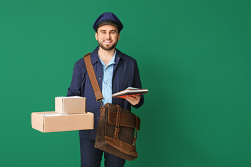 Handsome young postman on color background