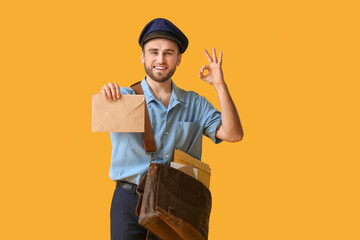 Handsome young postman on color background - obrazy, fototapety, plakaty