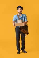 Handsome young postman on color background