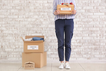 Woman with donations near brick wall