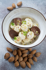 White bowl with vareniki or curd dumplings over beige stone background, studio shot, selective focus