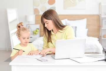 Working mother with her little daughter at home