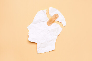 Torn paper human head with plaster on color background. Concept of dementia