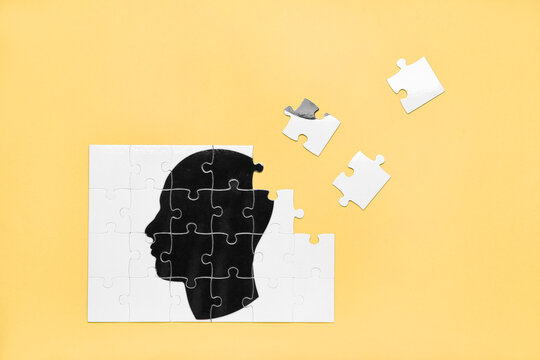 Puzzle with drawn human head on color background. Concept of dementia