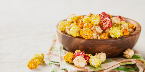 color popcorn in a bowl on a table, selective focus, copy space
