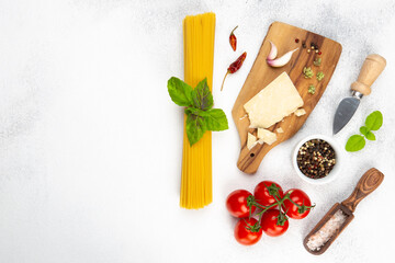 Fototapeta na wymiar Ingredients for perfect pasta:raw Spaghetti,fresh tomatoes,dried oregano,parmesan cheese,fresh Basil leaves,garlic,pink sea salt,dried pepper.Top view.