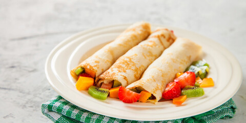 pancakes or crepes with fruit salad, selective focus, copy space