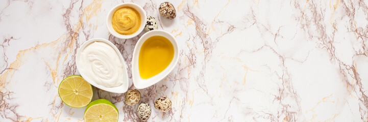 homemade mayonnaise and ingredients - a lime, olive oil, quail eggs and mustard, selective focus, copy space, top view