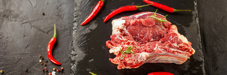 piece of raw meat of beef on a board with spices, selective focus, copy space, dark photo