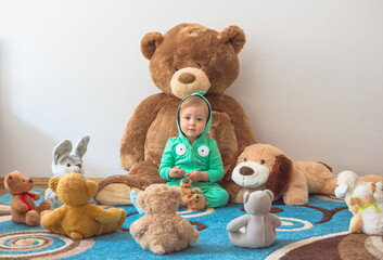 Cute child having fun playing with his teddy bears and plush toys, at home