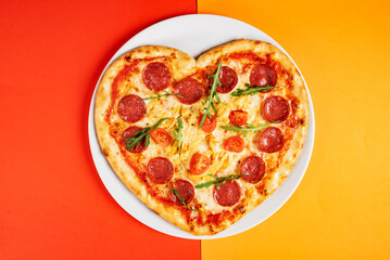 Heart shaped pizza with meat and vegetables. Food concept of romantic love for Valentines Day.