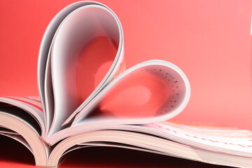 Magazine zu einem Herz geformt mit rotem Hintergrund steht für die Liebe zum Lesen und...