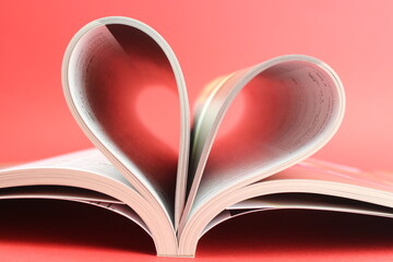 Magazine zu einem Herz geformt mit rotem Hintergrund steht für die Liebe zum Lesen und...