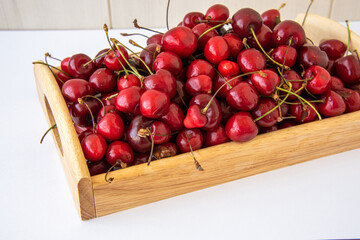 cherry berries on a wooden tray on a white background