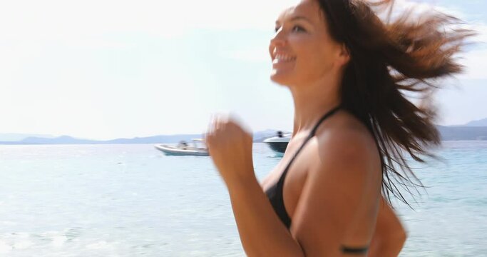 MS Woman in bikini running on beach / La Maddalena island, Sardinia, Italy