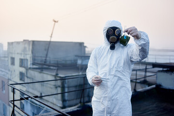 Focus on researcher hands, holding glass flask with blue reagent and tweezers. Scientific research...
