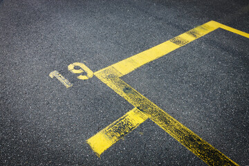 yellow lines on asphalt, number nineteen, space for text, 
covid 19, street marks with number