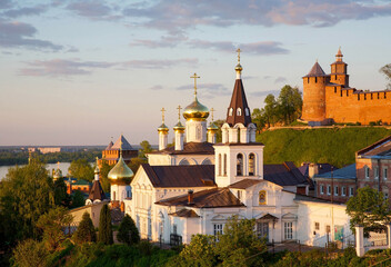 Orthodox Church with domes and spires and the a Kremlin in evening light in the Russian town of Nizhny Novgorod - obrazy, fototapety, plakaty