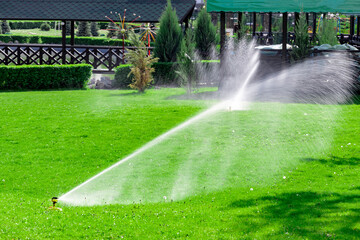 Watering the green lawn in the park. Selective focus.