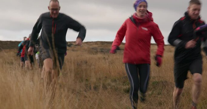 MS Group of people running in landscape / Yorkshire Moors, Yorkshire, UK