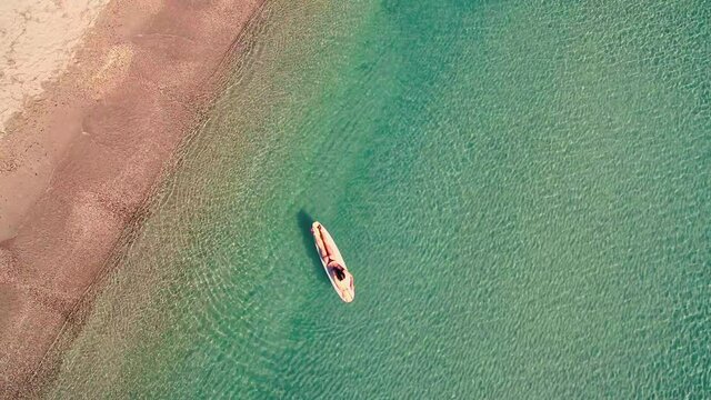 AERIAL ZO WS Woman on surfboard floating on sea / Cagliari, Sardinia, Italy