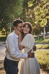 A guy and a girl are walking in the park. Romantic date evening walk. The relationship between people is love and tenderness.