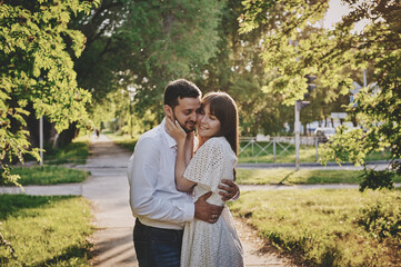 A guy and a girl are walking in the park. Romantic date evening walk. The relationship between people is love and tenderness.