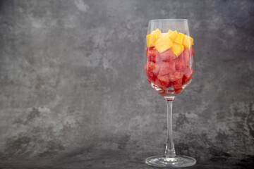 Pieces of mango and watermelon in glass wine.